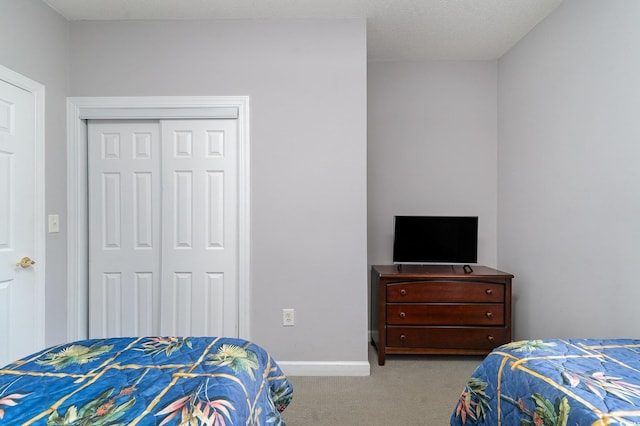 bedroom featuring a closet and light colored carpet