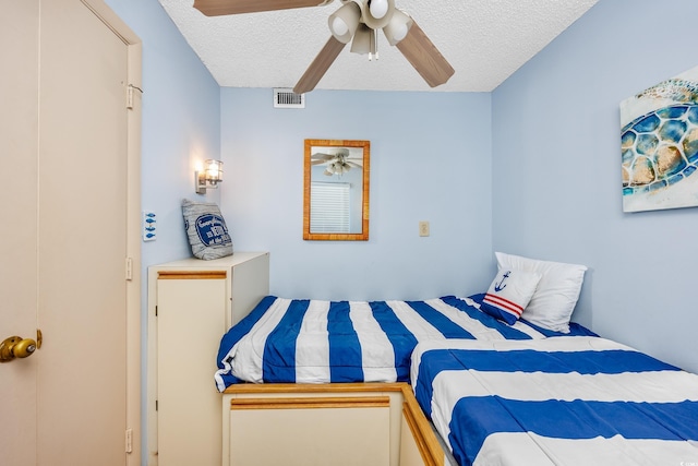 bedroom featuring ceiling fan and a textured ceiling