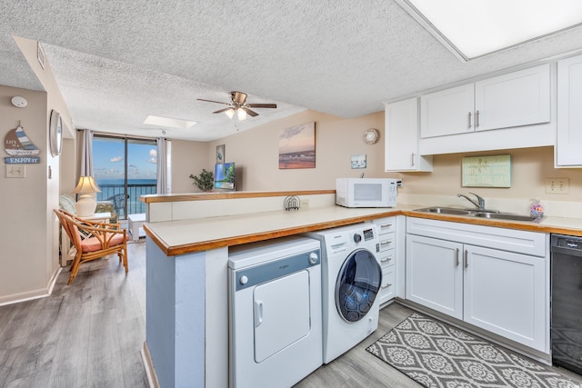 kitchen with floor to ceiling windows, sink, black dishwasher, kitchen peninsula, and white cabinets