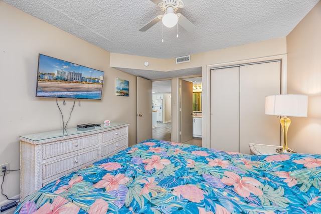 bedroom featuring ceiling fan, a closet, and a textured ceiling