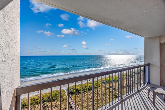 balcony featuring a beach view and a water view