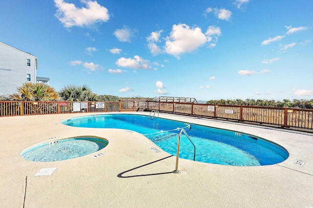 view of swimming pool featuring a patio and a hot tub