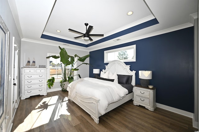 bedroom featuring a tray ceiling, crown molding, ceiling fan, and dark wood-type flooring