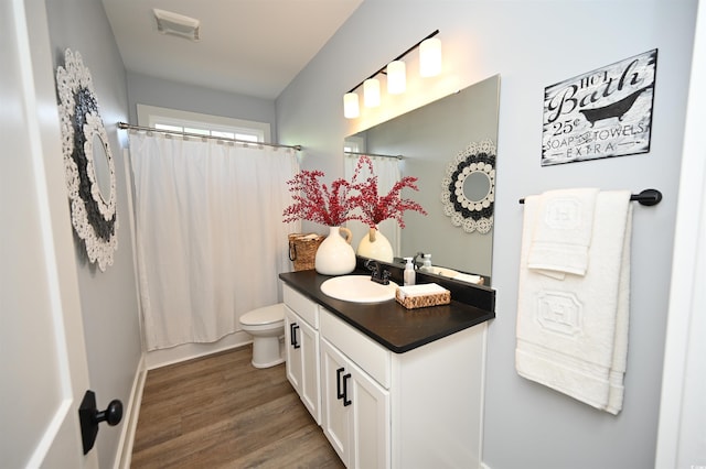 full bathroom with shower / bath combo with shower curtain, toilet, vanity, and hardwood / wood-style flooring