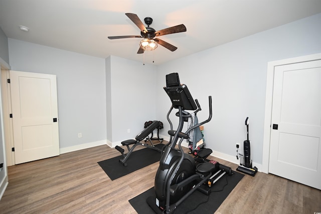 exercise area with baseboards, wood finished floors, and ceiling fan