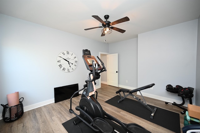 workout area featuring baseboards, wood finished floors, and ceiling fan