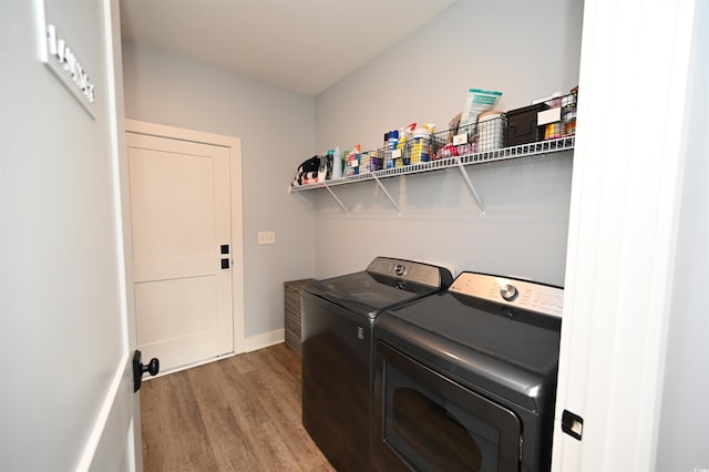 laundry room featuring washing machine and clothes dryer, wood finished floors, laundry area, and baseboards