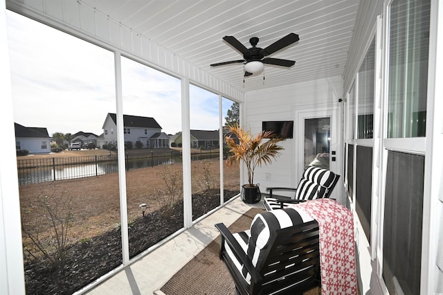 sunroom / solarium featuring a water view, a residential view, and ceiling fan