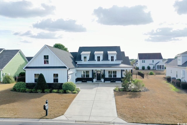 modern farmhouse featuring board and batten siding, a standing seam roof, metal roof, and concrete driveway