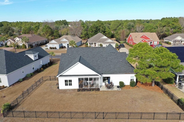 exterior space featuring a residential view, a patio, a fenced backyard, and a shingled roof