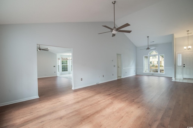 unfurnished living room with a chandelier, wood-type flooring, and high vaulted ceiling