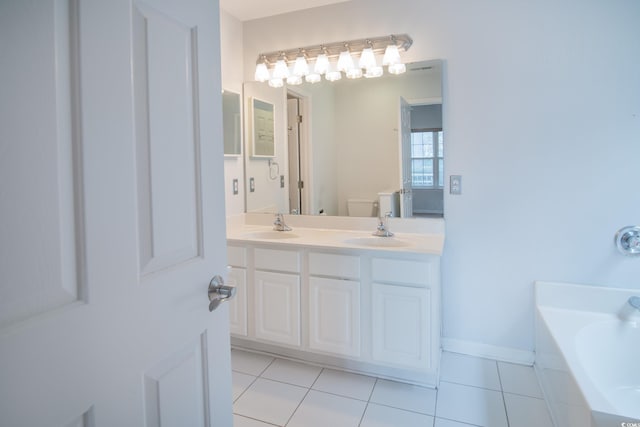 bathroom featuring tile patterned floors, a tub to relax in, vanity, and toilet