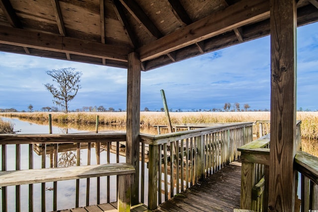 wooden terrace featuring a rural view and a water view