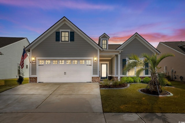 view of front of house with brick siding, a yard, and driveway