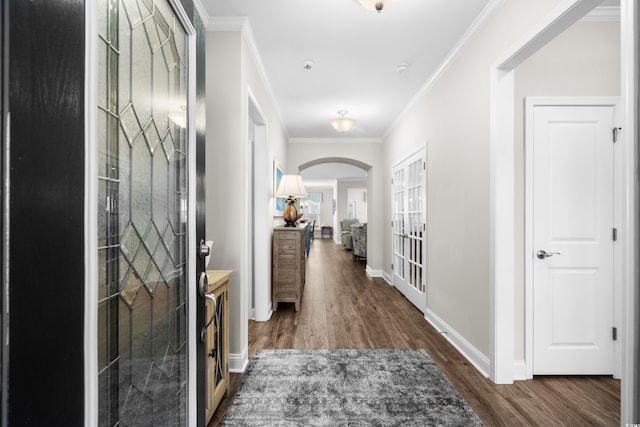 hall featuring baseboards, arched walkways, dark wood-style floors, and ornamental molding