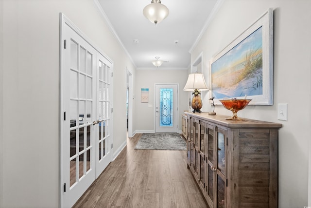 entryway with baseboards, french doors, ornamental molding, and wood finished floors