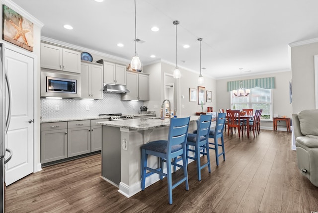 6550 Anterselva Dr, Myrtle Beach, SC 29572 - kitchen featuring stainless steel appliances, gray cabinetry, a sink, dark wood finished floors, and ornamental molding