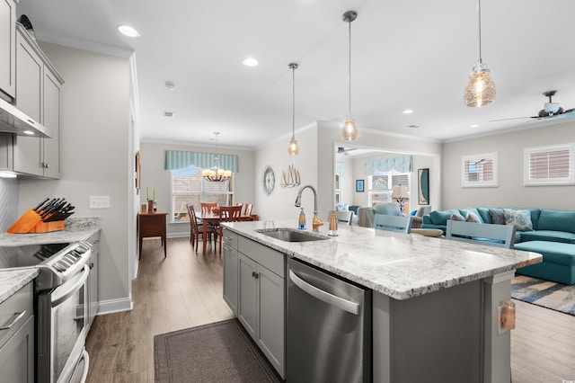 6550 Anterselva Dr, Myrtle Beach, SC 29572 - kitchen featuring stainless steel appliances, gray cabinets, a sink, open floor plan, and ornamental molding