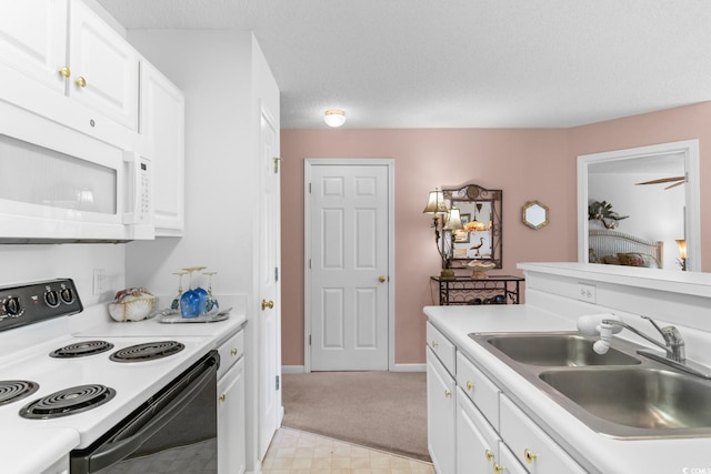 kitchen with white appliances, light carpet, sink, a textured ceiling, and white cabinetry