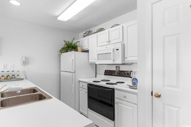 kitchen featuring a textured ceiling, white cabinetry, white appliances, and sink