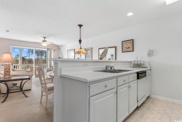 kitchen featuring kitchen peninsula, white dishwasher, ceiling fan, sink, and white cabinets