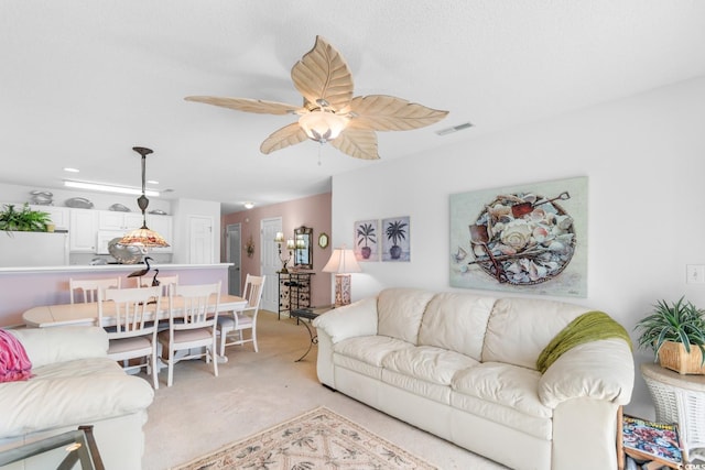 carpeted living room with ceiling fan