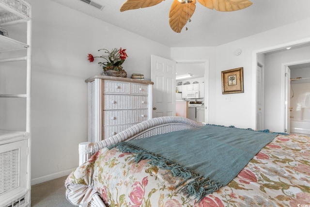 carpeted bedroom with ensuite bath and ceiling fan