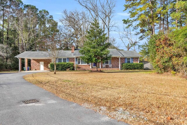 single story home with a carport and a front lawn