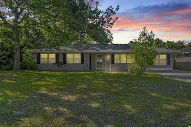 single story home featuring a lawn