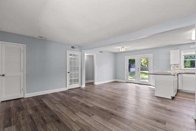 unfurnished living room featuring hardwood / wood-style flooring and french doors