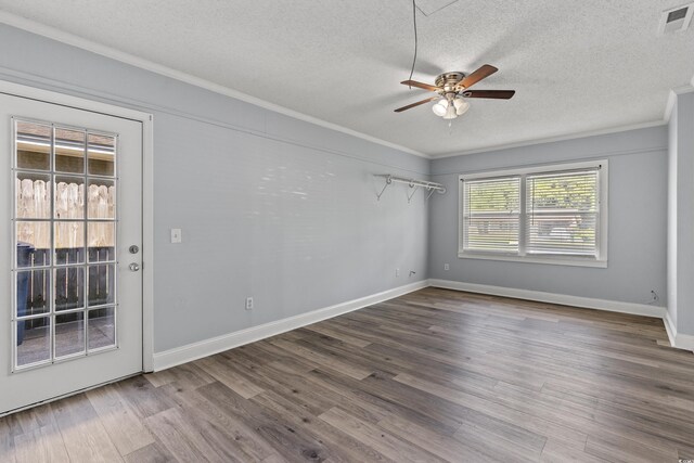 spare room with ceiling fan, ornamental molding, a textured ceiling, stacked washer / dryer, and brick wall