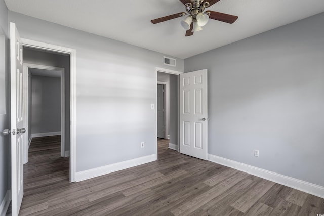 unfurnished bedroom featuring ceiling fan and dark hardwood / wood-style floors