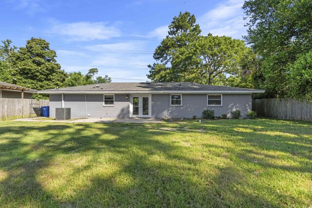 rear view of house featuring a yard and central AC unit