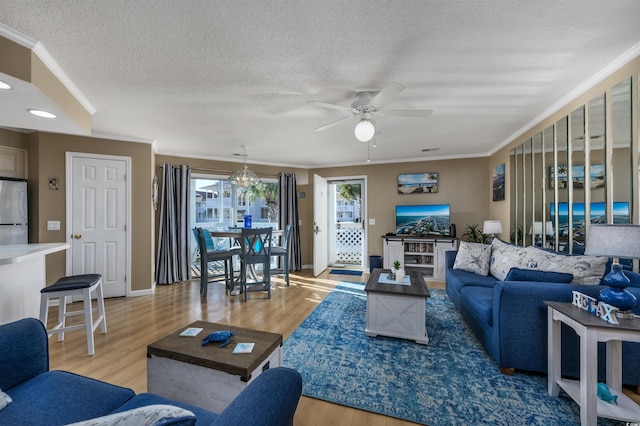 living room featuring ceiling fan, crown molding, wood-type flooring, and a textured ceiling