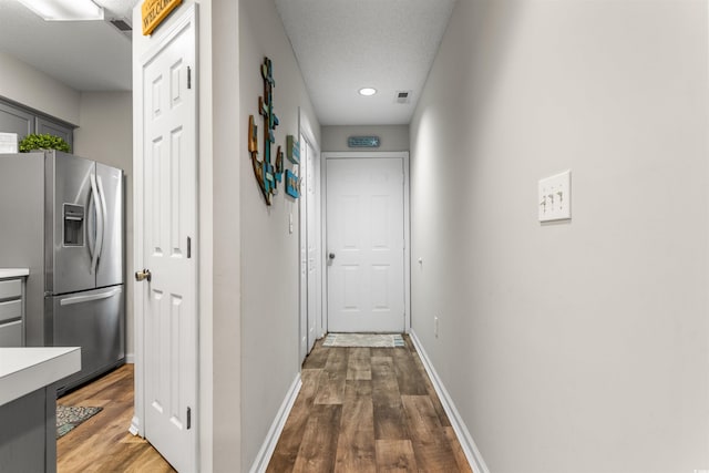 corridor with dark wood-type flooring and a textured ceiling