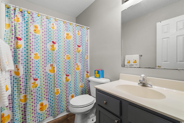 bathroom with hardwood / wood-style floors, vanity, toilet, and a textured ceiling