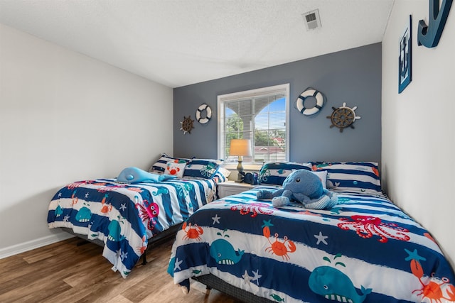 bedroom with a textured ceiling and hardwood / wood-style flooring