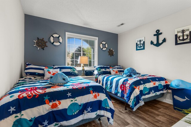 bedroom featuring hardwood / wood-style floors and a textured ceiling