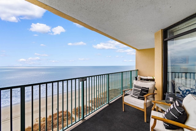 balcony featuring a water view and a view of the beach