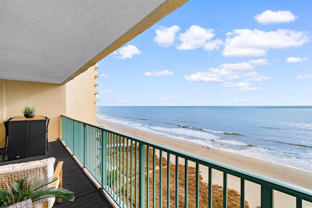 balcony featuring a water view and a beach view