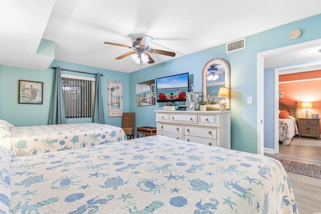 bedroom with light hardwood / wood-style floors and ceiling fan