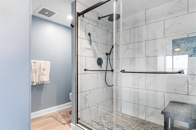 bathroom featuring toilet, an enclosed shower, and hardwood / wood-style flooring