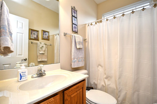 bathroom featuring vanity, toilet, and curtained shower