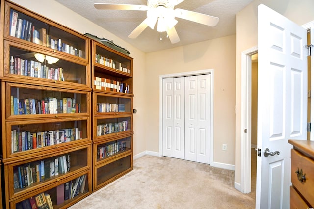 interior space featuring light carpet and ceiling fan