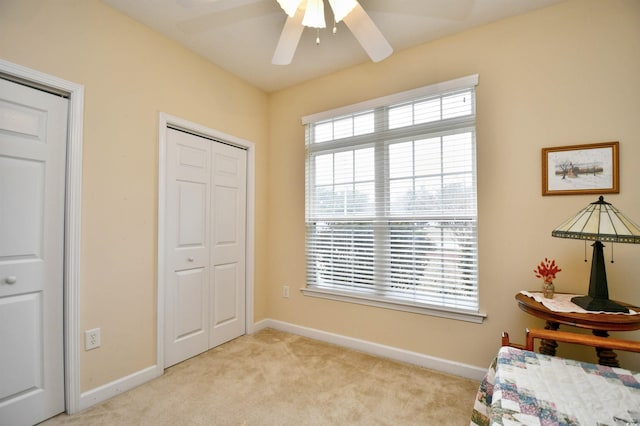 unfurnished bedroom featuring ceiling fan, a closet, and light colored carpet