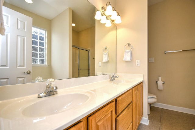 bathroom featuring toilet, vanity, tile patterned floors, and an enclosed shower