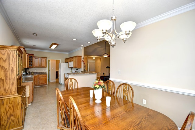 tiled dining area with ceiling fan with notable chandelier, a textured ceiling, crown molding, and sink