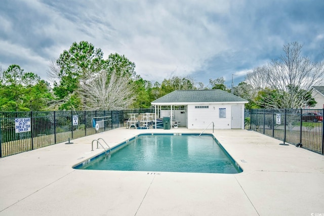 view of pool with an outbuilding and a patio