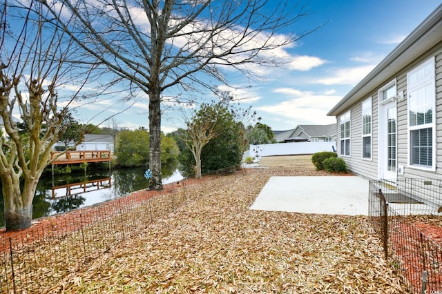 view of yard with a water view and a patio