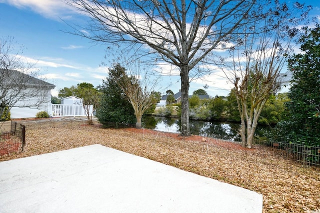 view of yard with a water view and a patio